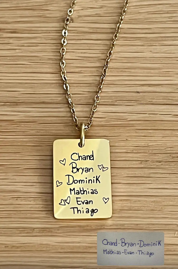 ciondolo placcato oro con incisione di nomi presi da un biglietto con l'aggiunta di cuori